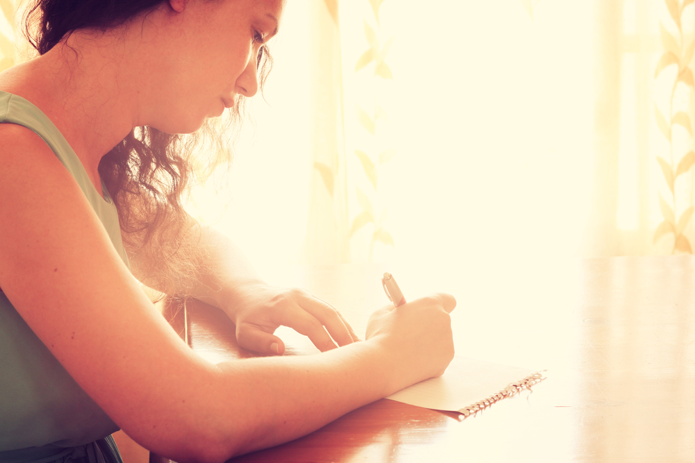 woman writing letter in sunshine